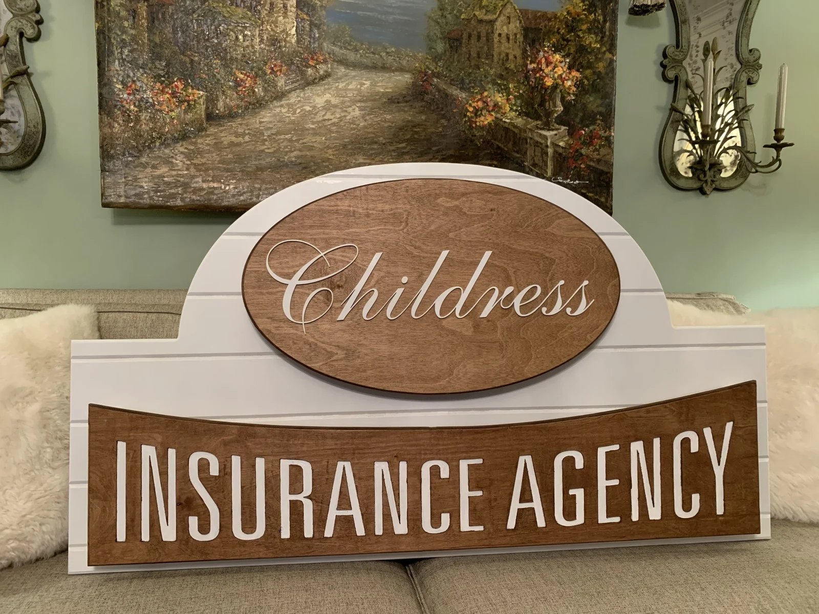 Layered Childress Insurance Agency sign with white lettering and stained wood