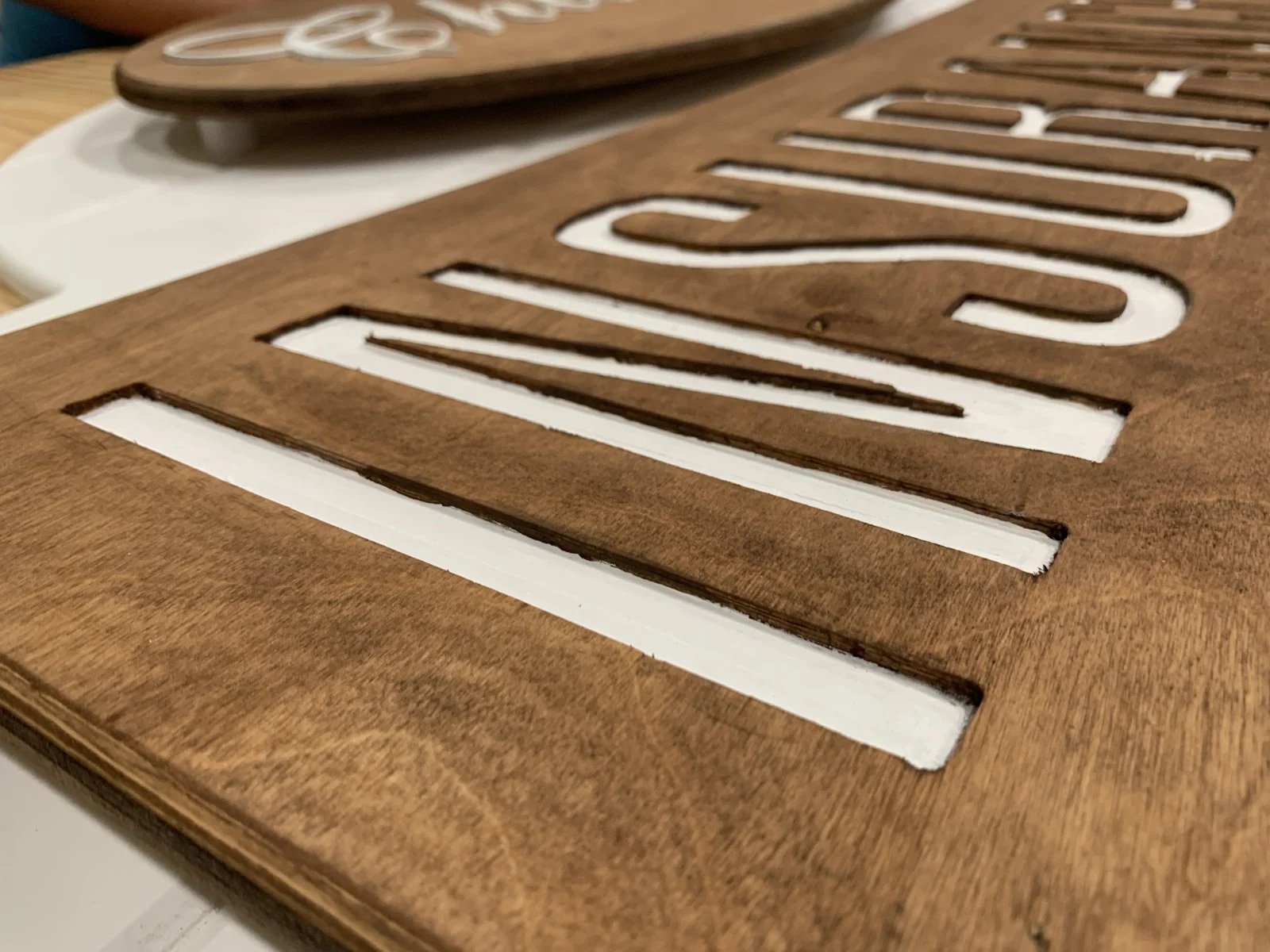 Raised white business lettering on stained wood