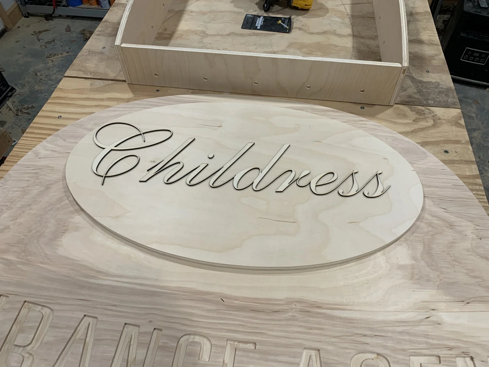Carved business name on an unfinished wood panel
