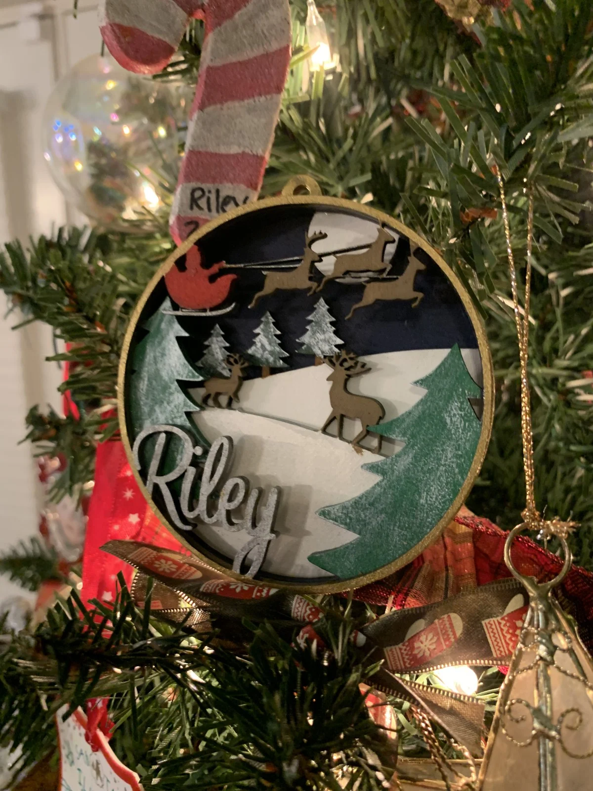 Layered trees, deer and winter scenery in a personalized ornament