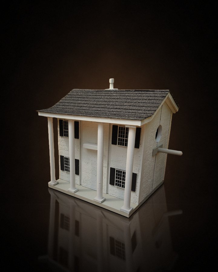 White columned two-story birdhouse with a shingle roof